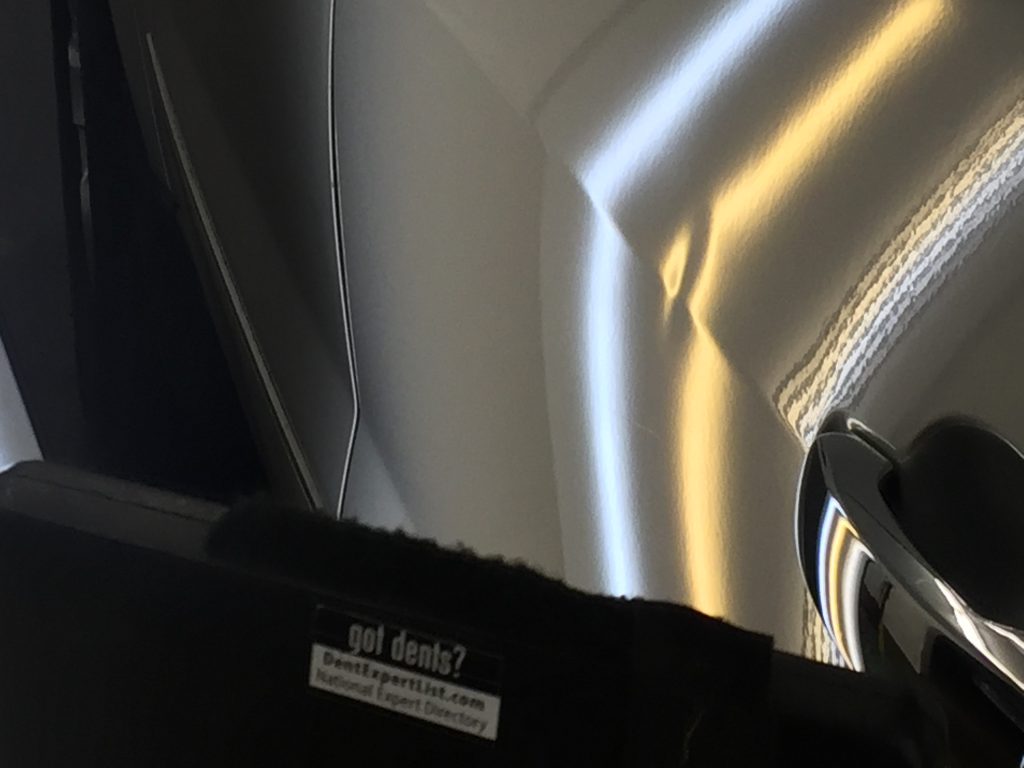 PDR light reflected along the door of a 2015 Chevy Traverse during a body line dent repair
