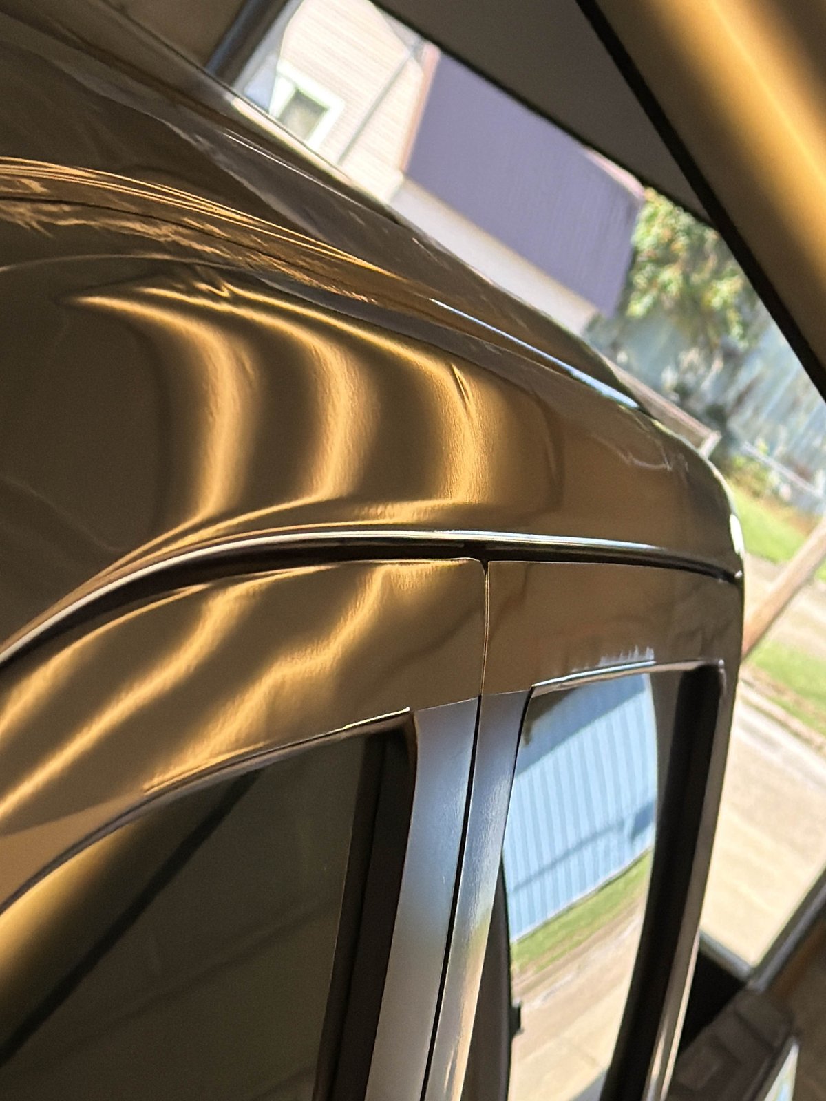 Driver-side roof rail of a silver 2024 Toyota Tundra with hail dents in the reflected light