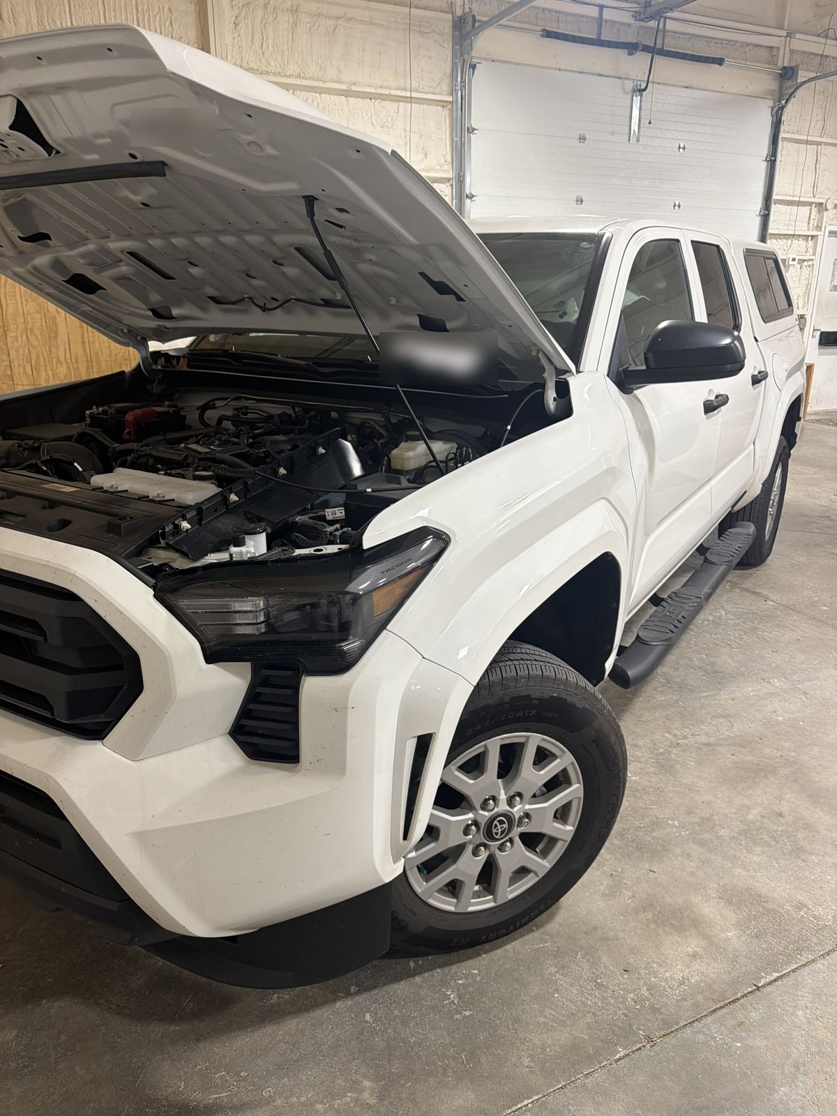 White 2025 Toyota Tacoma SR in the 217 Dent shop with the hood open