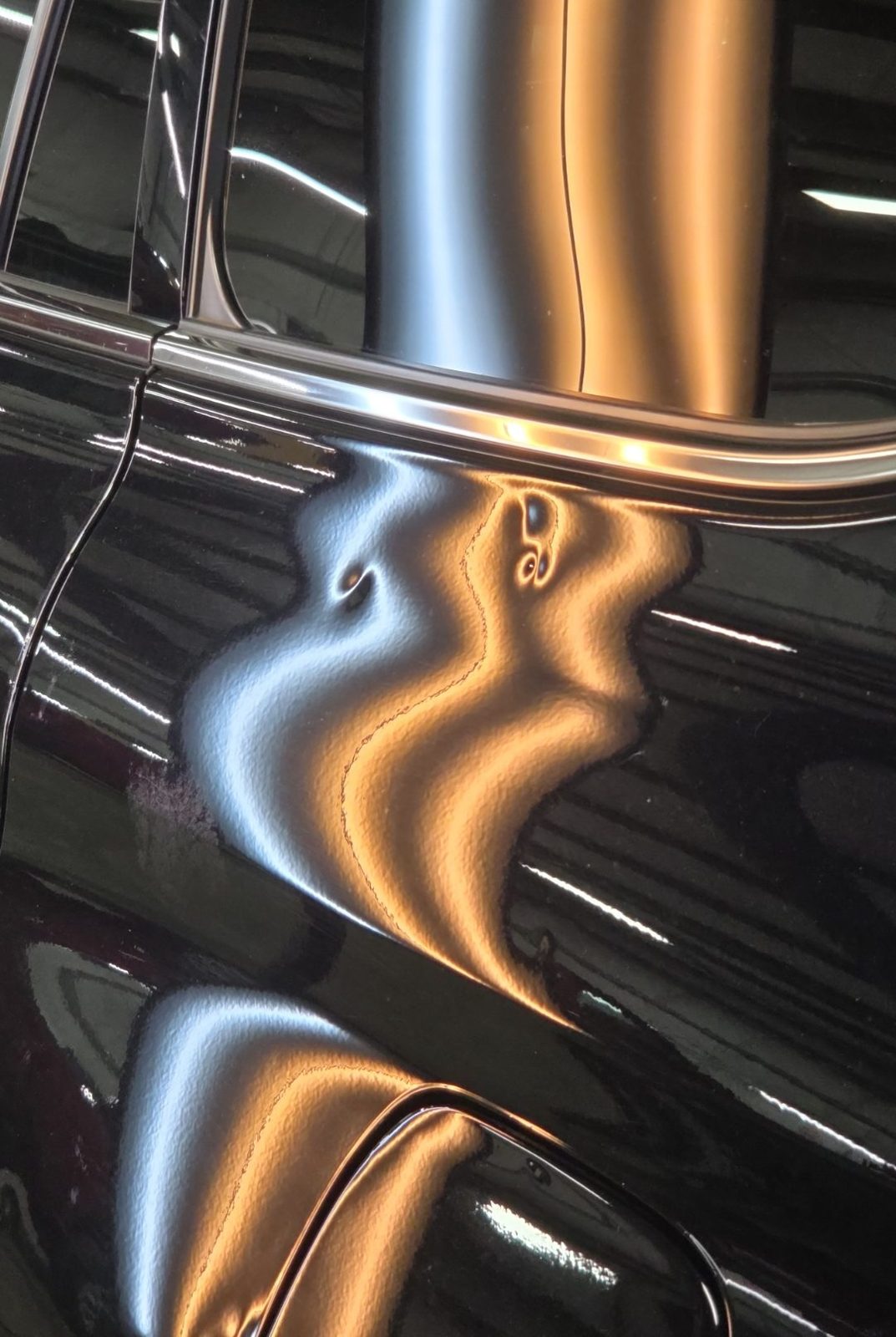 Driver quarter panel of a black 2025 Toyota Highlander Hybrid under PDR light